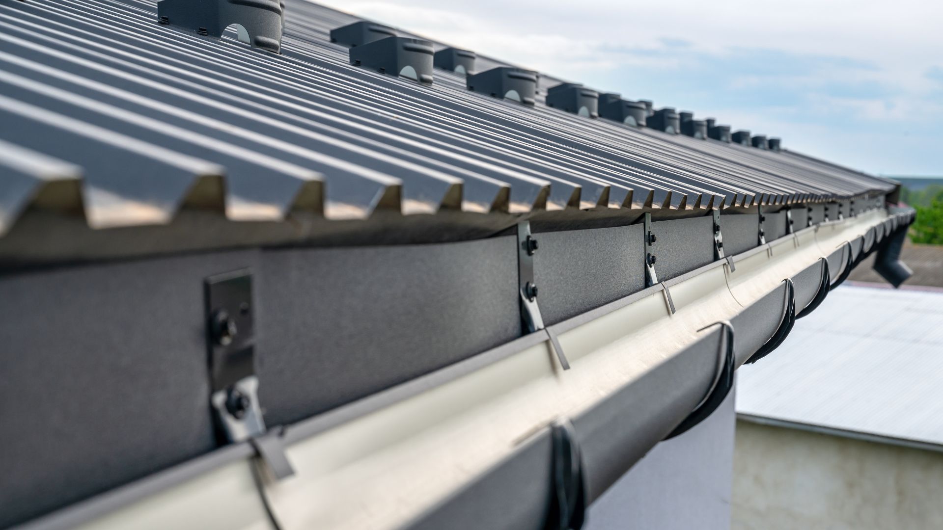 Close-up of modern roof with gutters and solar panel mounting system