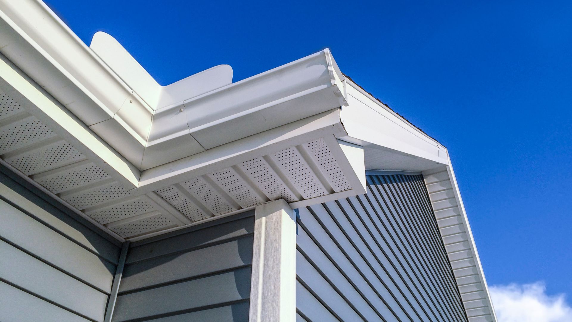 Modern white and gray building exterior with geometric roof detail