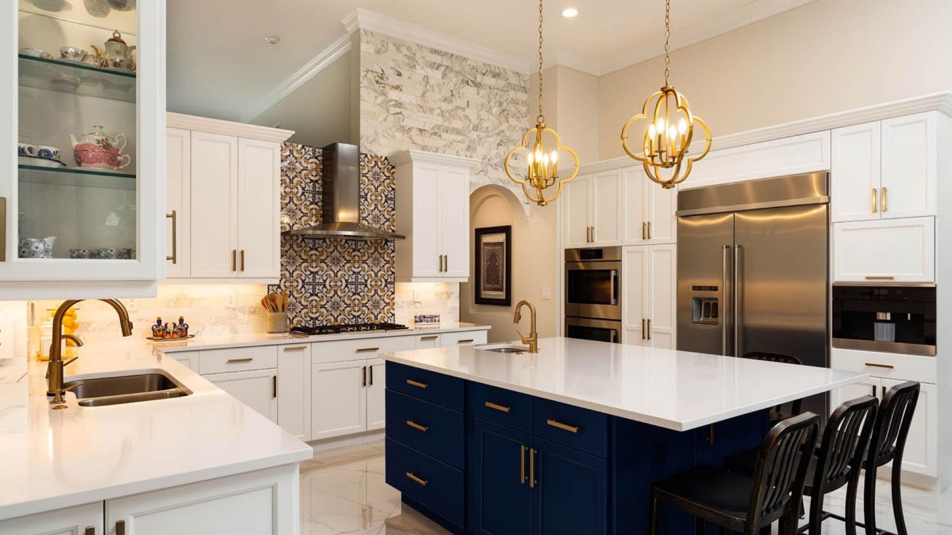 Elegant kitchen with white cabinets, blue island, and gold light fixtures